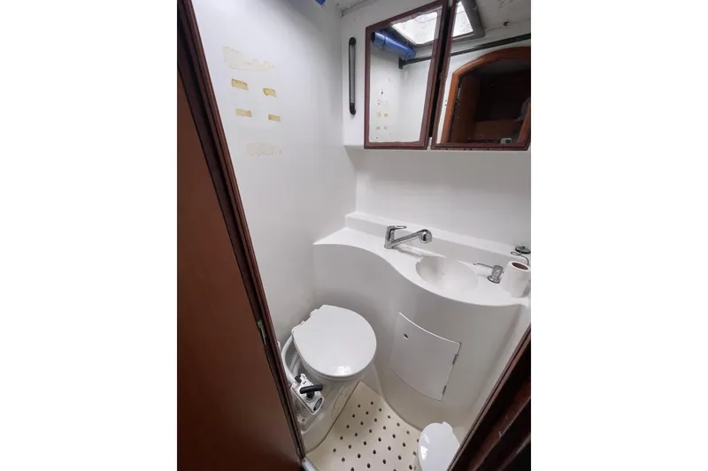 Slide: The Image of Compact bathroom in 2004 Lagoon 570 yacht with toilet, sink, and mirror. - 41
