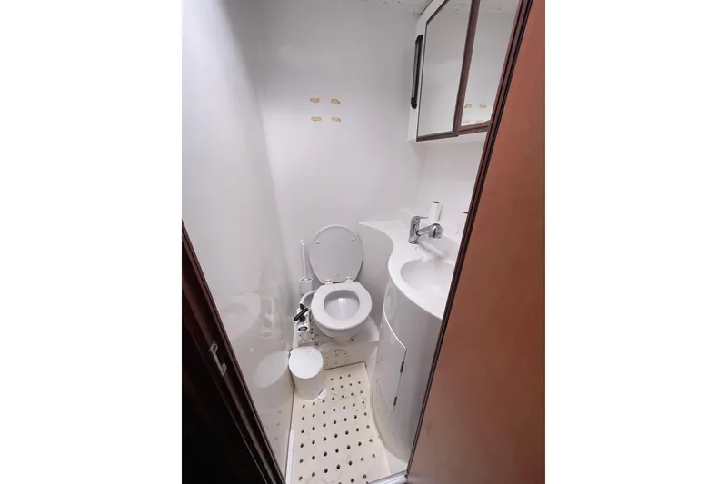 Slide: The Image of Compact bathroom in a 2004 Lagoon 570 yacht, featuring a toilet and sink. - 47