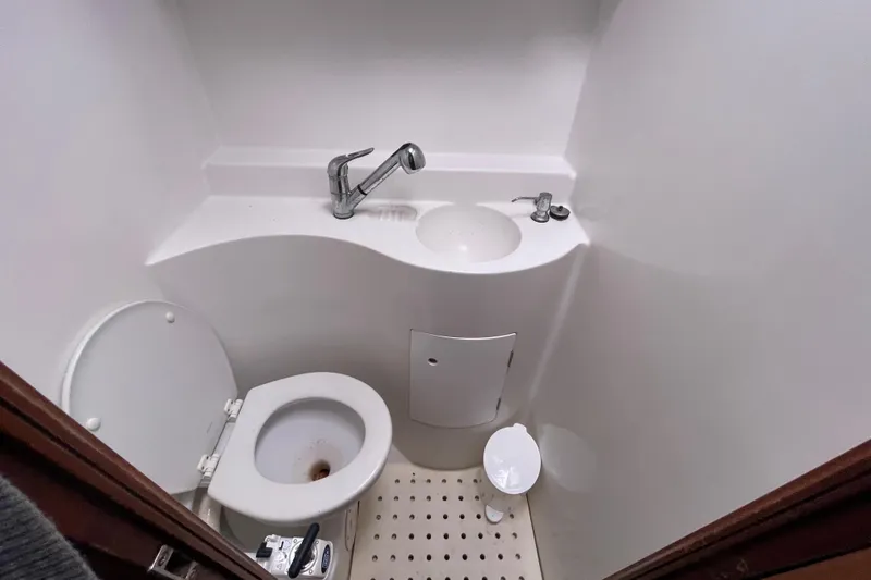 Slide: The Image of Compact bathroom in a 2004 Lagoon 570 yacht, featuring a toilet and sink. - 50