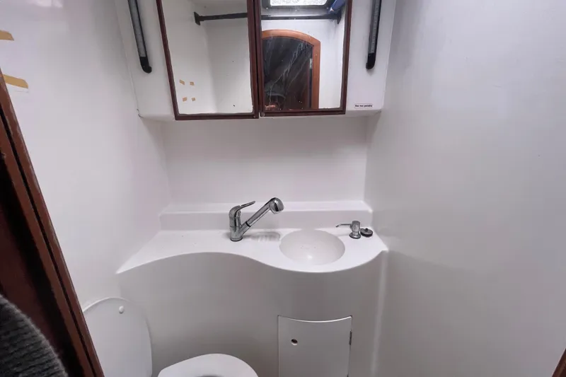 Slide: The Image of Compact bathroom in a 2004 Lagoon 570 yacht with sink, mirror, and toilet. - 51