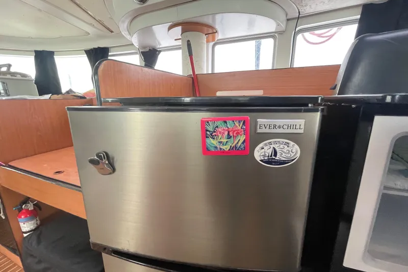 Slide: The Image of Stainless steel fridge in 2004 Lagoon 570 yacht interior with colorful stickers. - 54