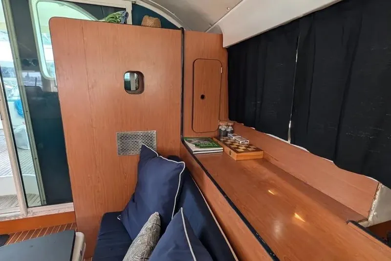 Slide: The Image of Interior of 2004 Lagoon 570 yacht with wooden paneling and cozy seating area. - 63