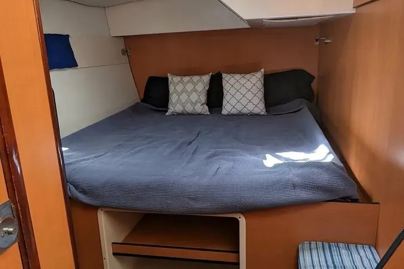 Slide: The Image of Cozy cabin interior of 2004 Lagoon 570 yacht with bed and pillows. - 66