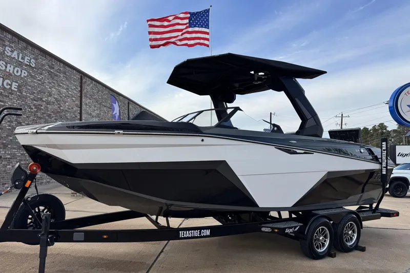 The Image of 2026 Tigé Z3 boat on trailer, displayed outdoors with American flag in background. - 1