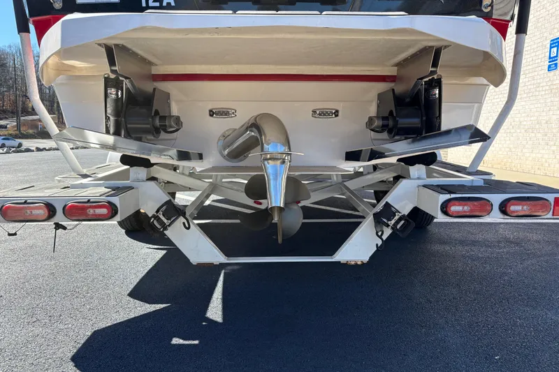 Slide: The Image of Rear view of 2022 Supra SL 400 boat on trailer, showcasing propeller and exhaust system. - 4