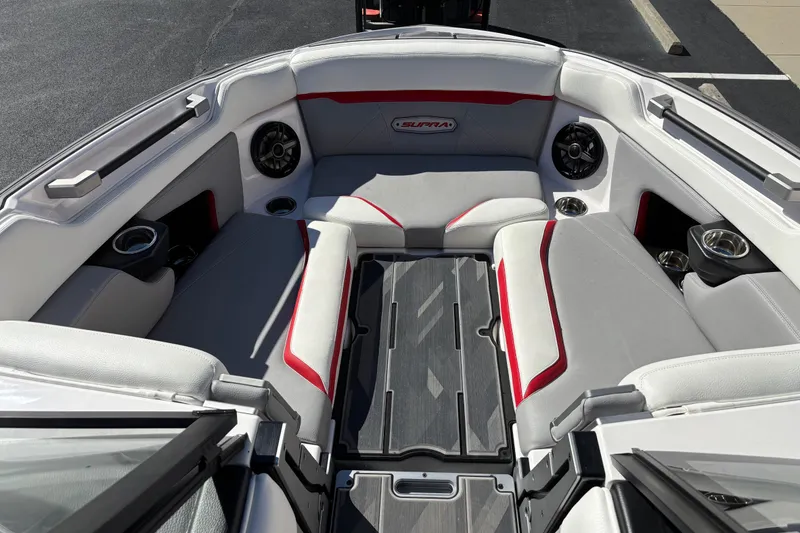 Slide: The Image of 2022 Supra SL 400 boat interior with gray and red seating, cup holders, and speakers. - 6