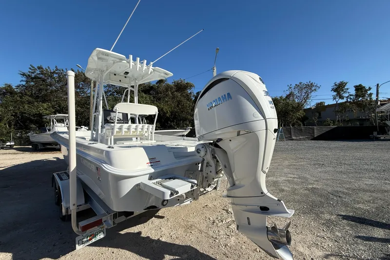 Slide: The Image of 2024 Contender 25 Bay boat with Yamaha outboard motor, parked on a trailer. - 11