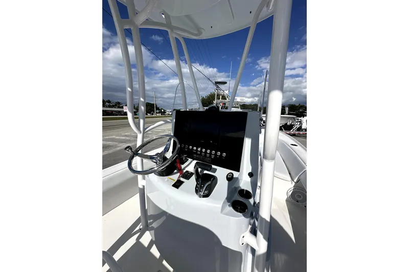 Slide: The Image of 2024 Contender 25 Bay boat console with steering wheel and controls. - 4