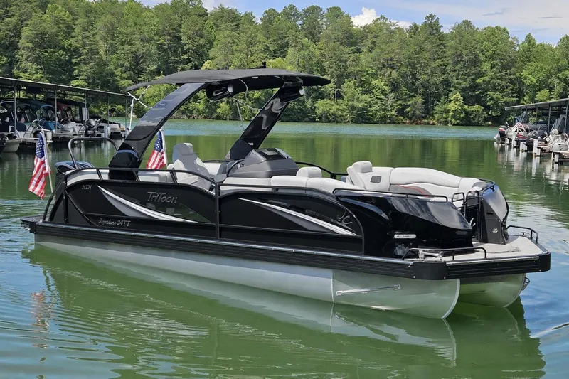 The Image of 2026 JC SportToon 24 TT DSL pontoon boat on a serene lake. - 0