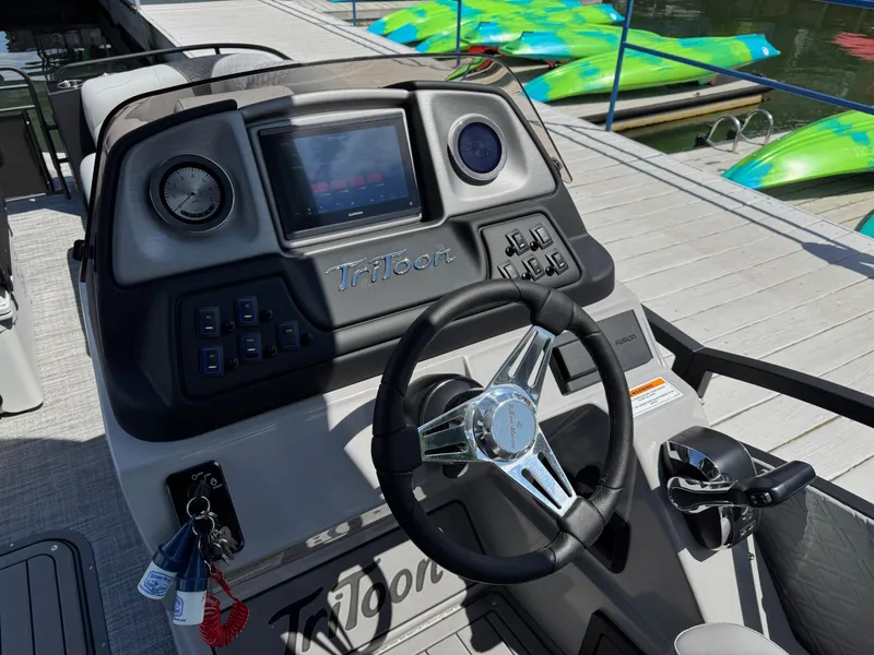 Slide: The Image of 2026 JC SportToon 24 TT DSL boat dashboard with steering wheel and control panel. - 17