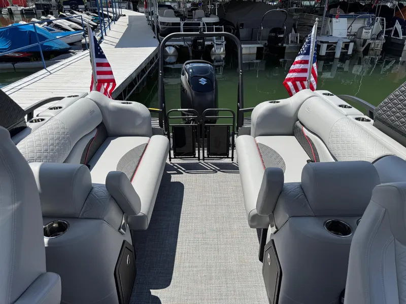 Slide: The Image of Luxury interior of 2026 JC SportToon 24 TT DSL pontoon boat with plush seating and American flags. - 19