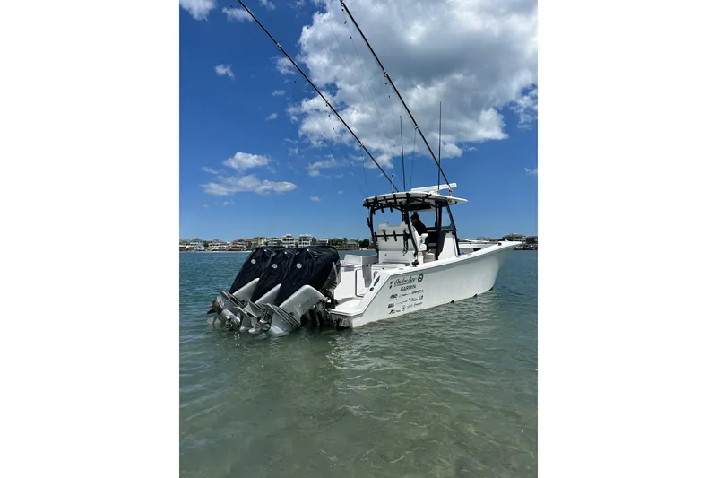 Slide: The Image of 2024 Onslow Bay 33 Tournament boat with triple engines in clear water under blue sky. - 3