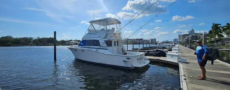 Slide: The Image of 1982 Bertram 38 Convertible boat docked at marina under clear blue sky. - 1