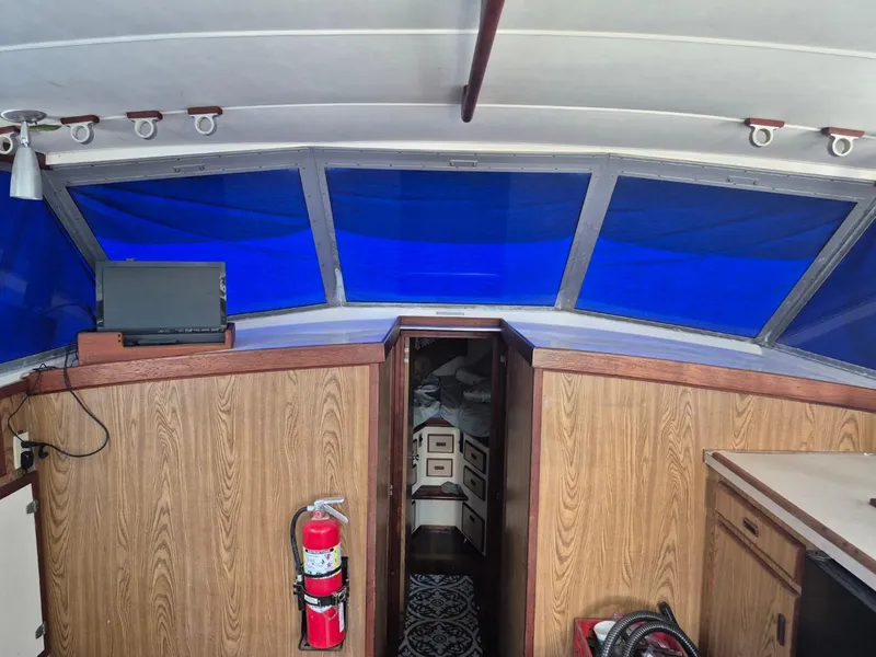 Slide: The Image of 1982 Bertram 38 Convertible interior with blue-tinted windows and wood paneling. - 17