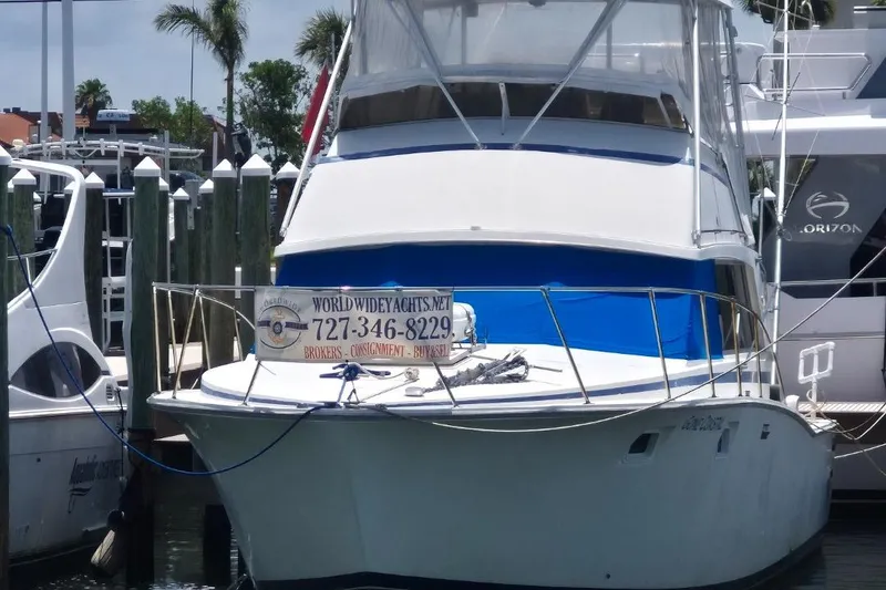Slide: The Image of 1982 Bertram 38 Convertible yacht docked at marina with contact sign displayed. - 22
