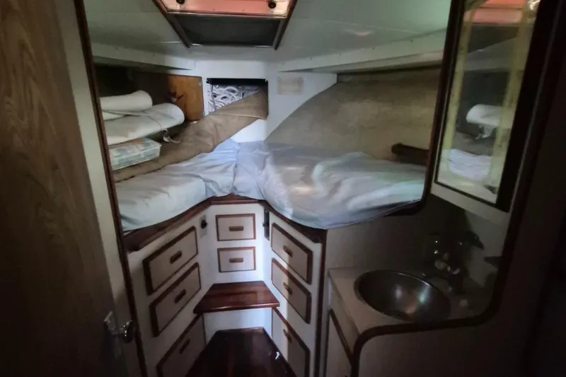 Slide: The Image of 1982 Bertram 38 Convertible cabin interior with bed, storage drawers, and sink. - 23