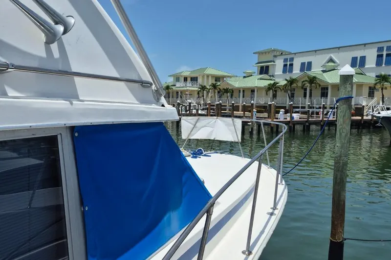 Slide: The Image of 1982 Bertram 38 Convertible yacht docked near waterfront homes. - 9