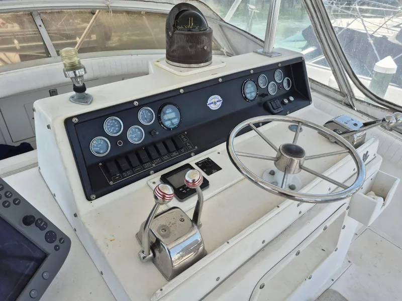 Slide: The Image of 1982 Bertram 38 Convertible helm with steering wheel, gauges, and controls. - 26