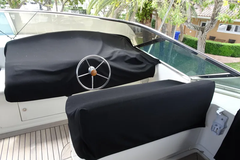 Slide: The Image of Helm of 2010 Azimut 100 Leonardo yacht with covered controls, surrounded by lush greenery. - 79