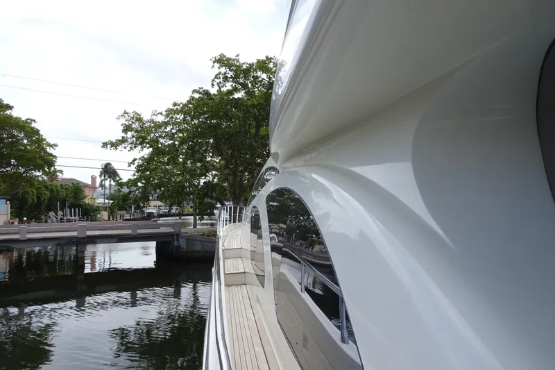 Slide: The Image of Azimut 100 Leonardo yacht docked near lush greenery and waterfront homes. - 89