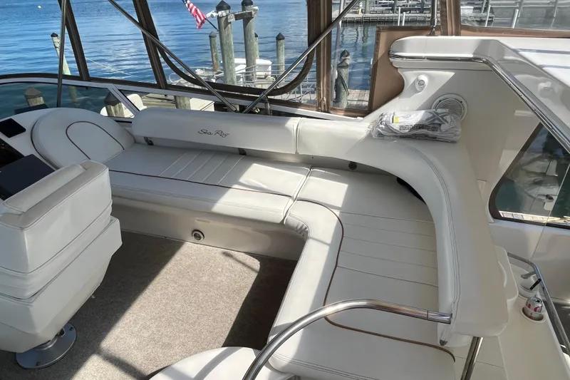 Slide: The Image of 1997 Sea Ray 420 Aft Cabin interior with white seating and lake view. - 15