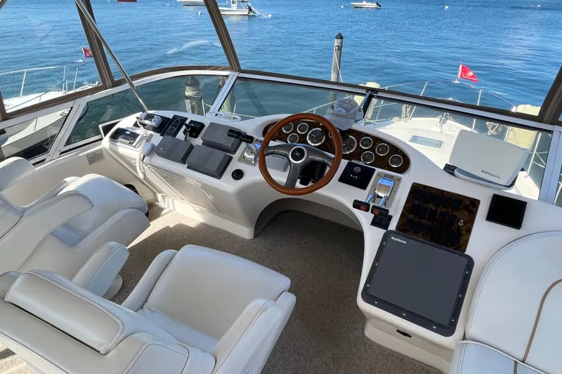 Slide: The Image of 1997 Sea Ray 420 Aft Cabin helm with luxurious seating and advanced navigation controls. - 16