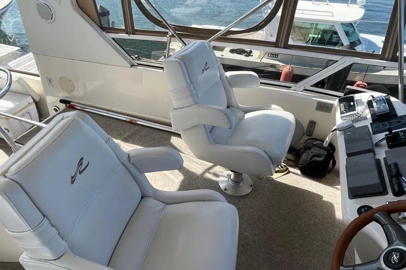 Slide: The Image of 1997 Sea Ray 420 Aft Cabin interior with white captain chairs and control panel. - 20