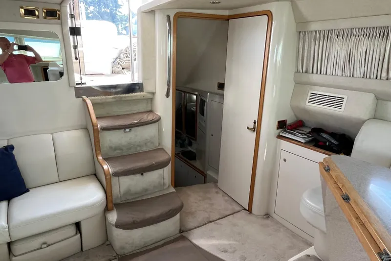 Slide: The Image of 1997 Sea Ray 420 Aft Cabin interior with stairs, seating, and cabinetry. - 26