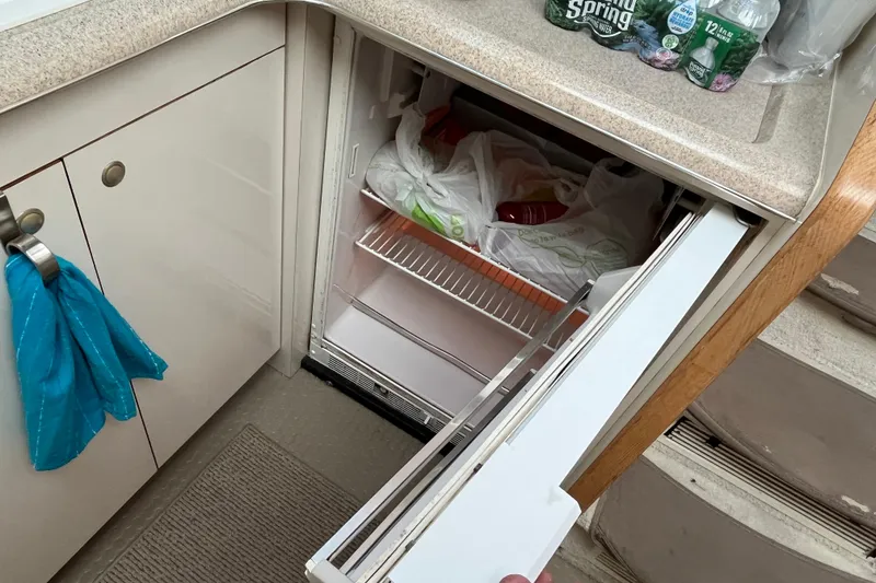 Slide: The Image of 1997 Sea Ray 420 Aft Cabin kitchen with open fridge and countertop items. - 30