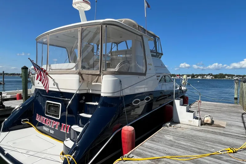 Slide: The Image of 1997 Sea Ray 420 Aft Cabin yacht docked at marina with clear blue sky. - 4