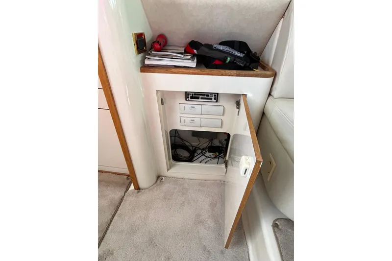 Slide: The Image of 1997 Sea Ray 420 Aft Cabin interior storage with open cabinet and electronic equipment. - 41