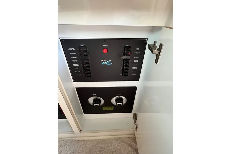 Slide: The Image of 1997 Sea Ray 420 Aft Cabin control panel with switches and dials inside cabinet. - 44