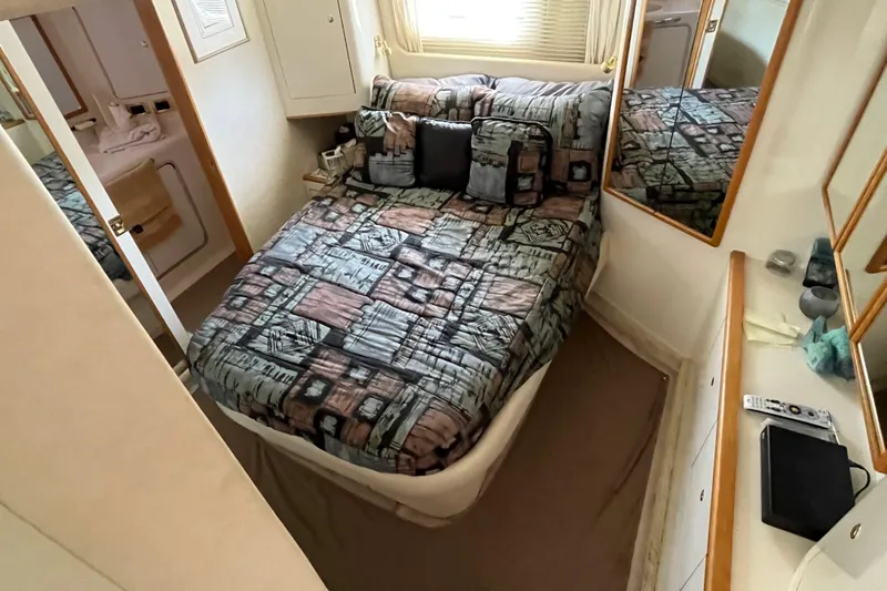 Slide: The Image of 1997 Sea Ray 420 Aft Cabin bedroom with patterned bedding and mirrored walls. - 45