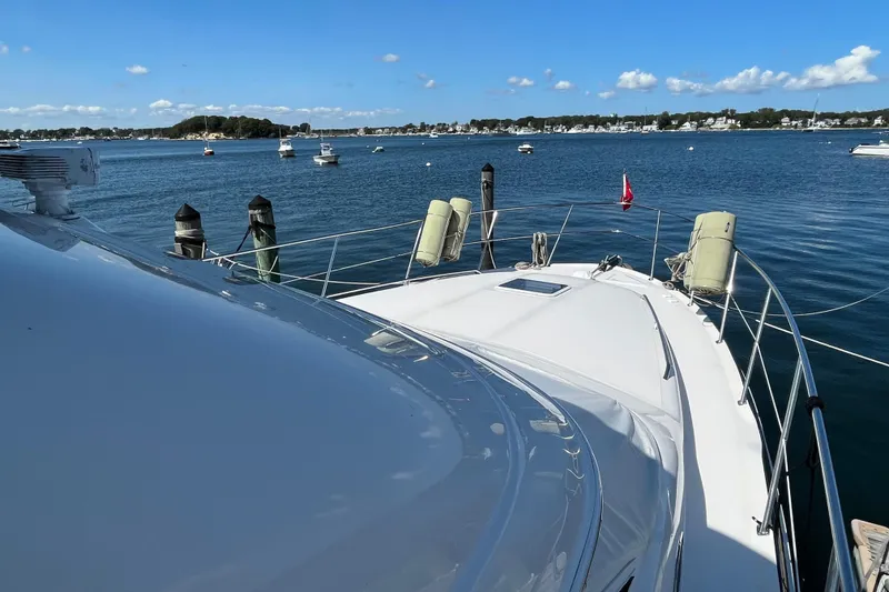 Slide: The Image of 1997 Sea Ray 420 Aft Cabin yacht docked in a scenic harbor. - 5
