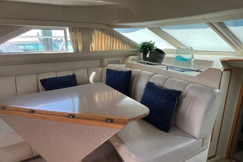 Slide: The Image of Interior of 1997 Sea Ray 420 Aft Cabin with dining area and blue cushions. - 63