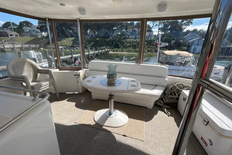 Slide: The Image of 1997 Sea Ray 420 Aft Cabin interior with seating, table, and marina view. - 65