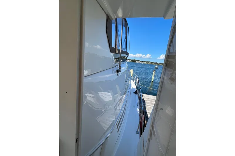 Slide: The Image of 1997 Sea Ray 420 Aft Cabin yacht docked by a scenic waterfront. - 67