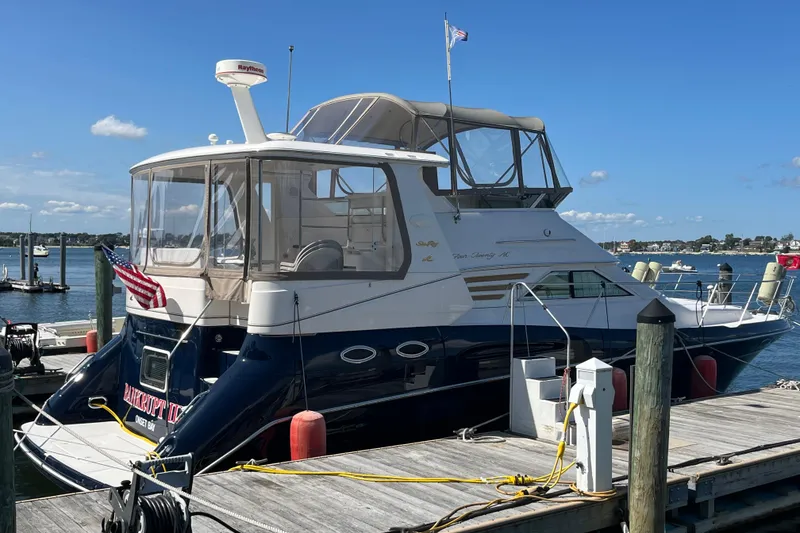 Slide: The Image of 1997 Sea Ray 420 Aft Cabin yacht docked at a marina on a sunny day. - 70