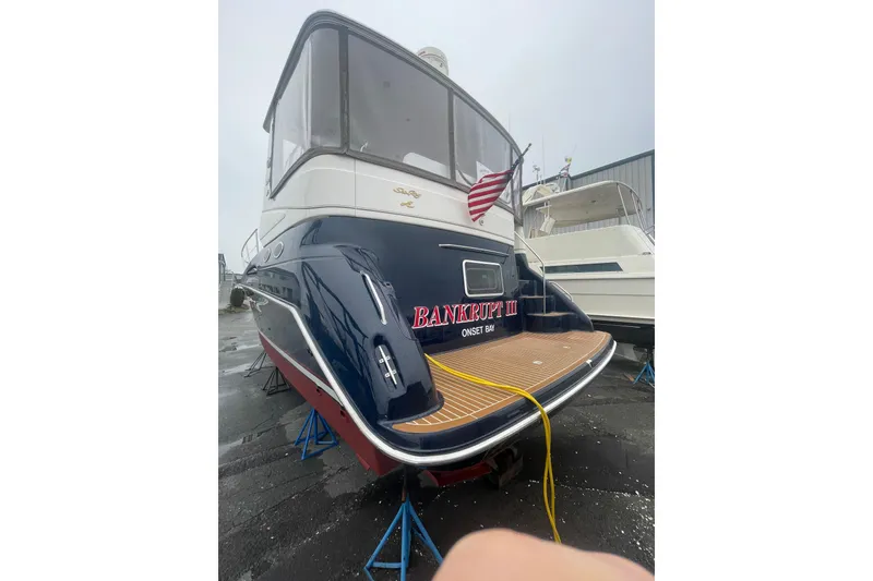 Slide: The Image of 1997 Sea Ray 420 Aft Cabin yacht on stands, rear view with American flag. - 71