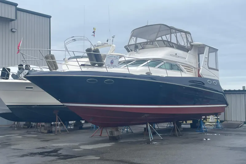 Slide: The Image of 1997 Sea Ray 420 Aft Cabin yacht on stands in a marina. - 72