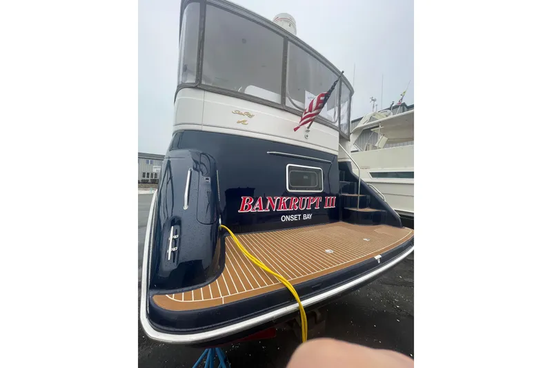 Slide: The Image of 1997 Sea Ray 420 Aft Cabin yacht with "Bankrupt III" name, docked at Onset Bay. - 74