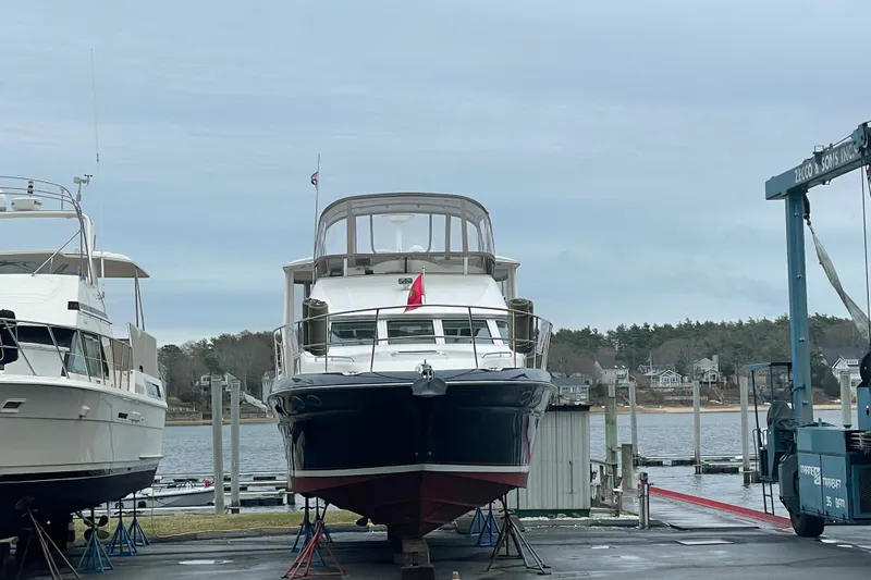 Slide: The Image of 1997 Sea Ray 420 Aft Cabin yacht docked at a marina, surrounded by water and trees. - 75