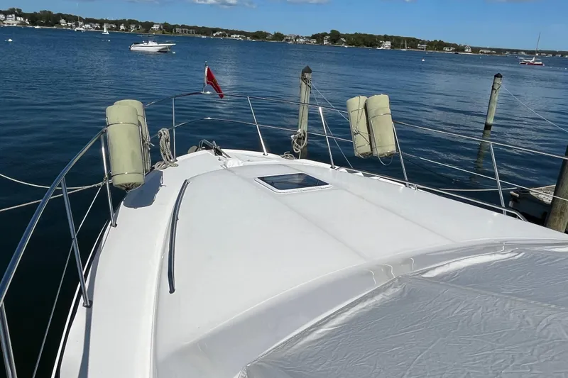 Slide: The Image of 1997 Sea Ray 420 Aft Cabin yacht docked on calm water, clear sky. - 8
