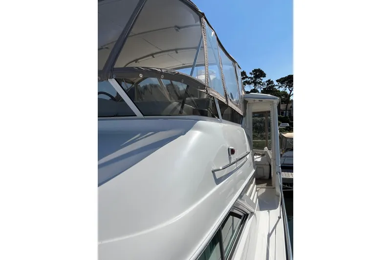 Slide: The Image of 1997 Sea Ray 420 Aft Cabin yacht with enclosed deck, docked under clear blue sky. - 9