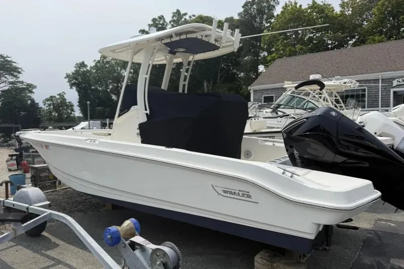 The Image of 2024 Boston Whaler 220 Dauntless boat displayed outdoors, side view. - 1