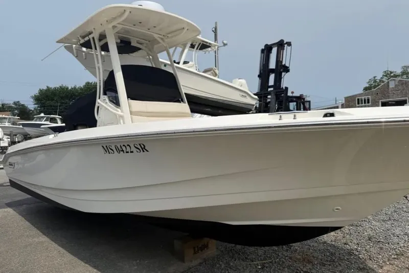 Slide: The Image of 2024 Boston Whaler 220 Dauntless boat in a marina setting, side view. - 12