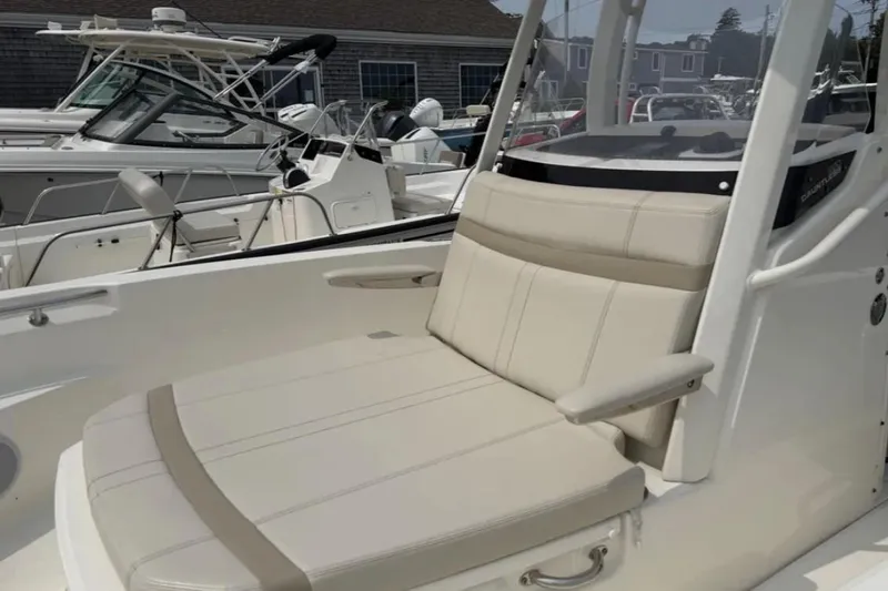 Slide: The Image of 2024 Boston Whaler 220 Dauntless boat interior with beige seating and console. - 3
