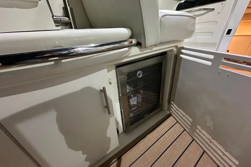 Slide: The Image of 1997 Sea Ray Sundancer 370 interior with open cabinet and mini fridge. - 13