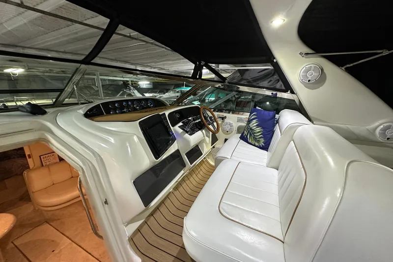 Slide: The Image of 1997 Sea Ray Sundancer 370 cockpit with white seating, wooden accents, and nautical decor. - 15