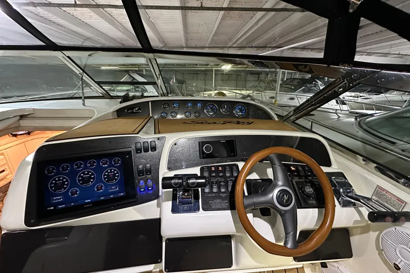 Slide: The Image of 1997 Sea Ray Sundancer 370 helm with modern controls and wooden steering wheel. - 16
